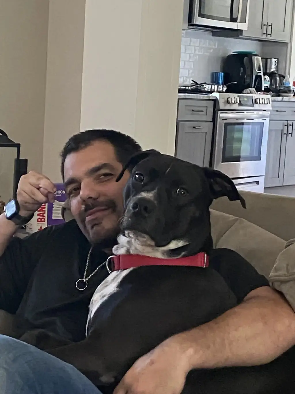 Anthony Mazzenga at home on the couch with his rescue dog Domino